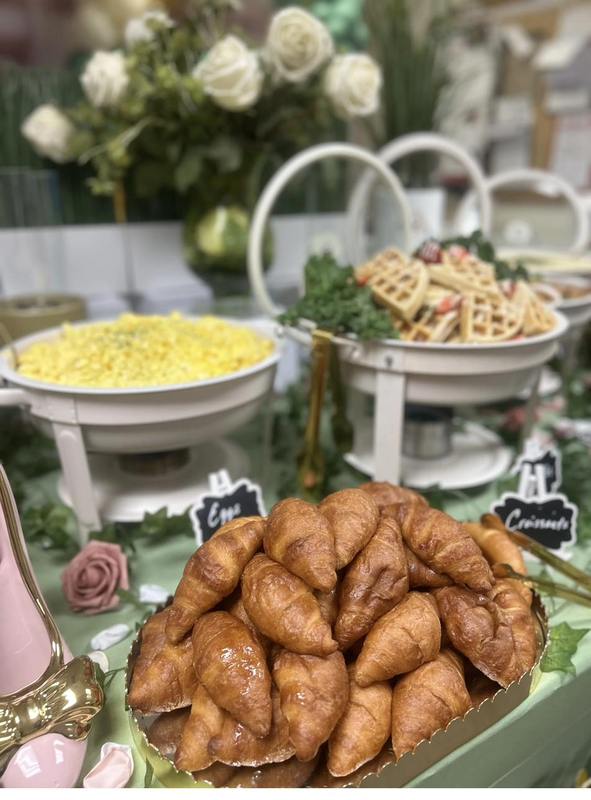 Brunch Spread Display Flavor and Flair Catering luxury brunch spread featuring golden croissants, scrambled eggs, and fresh waffles with white roses
